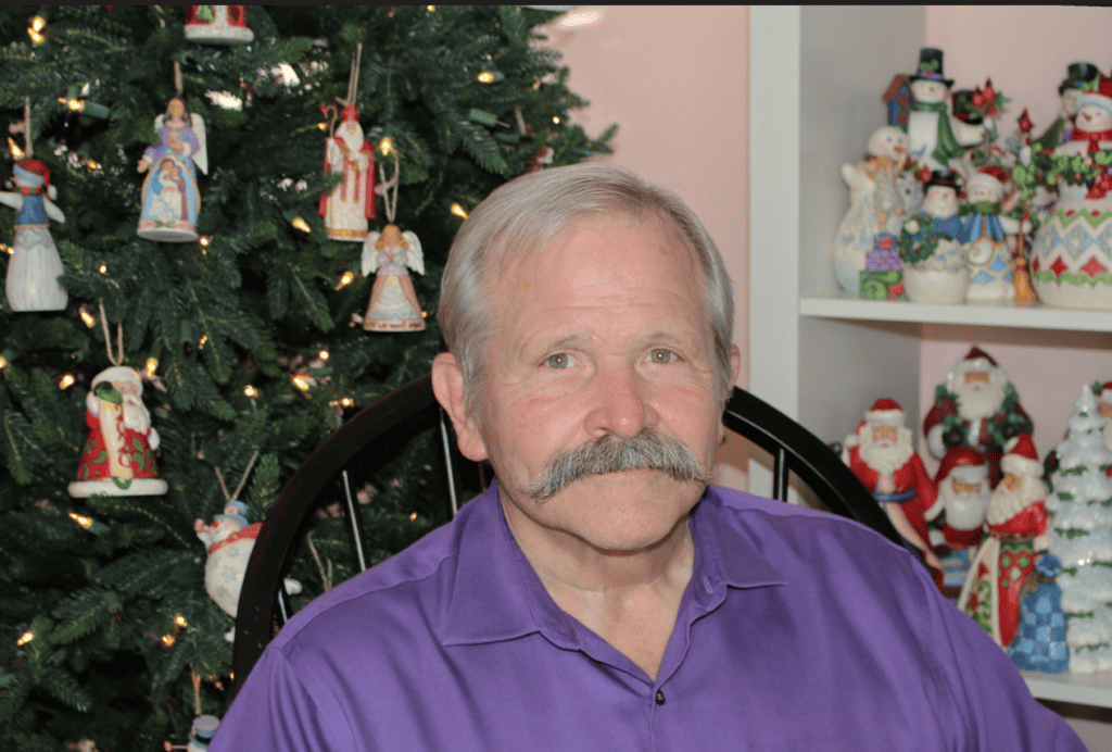 Jim Shore sitting in purple shirt